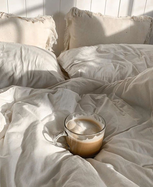 Vanilla latte on a fluffy white bed in the morning