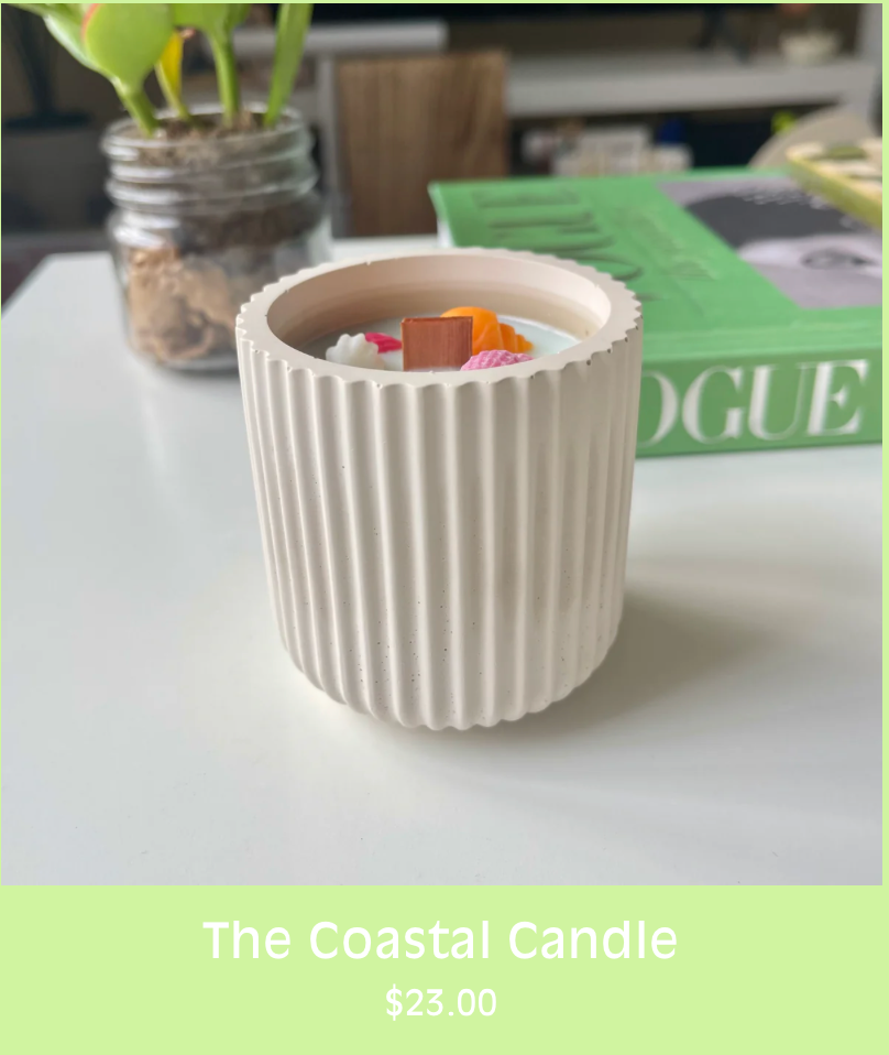 a small coastal concrete candle with colorful wax seashells