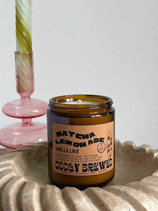 Candle in a glass jar with a label on a textured surface