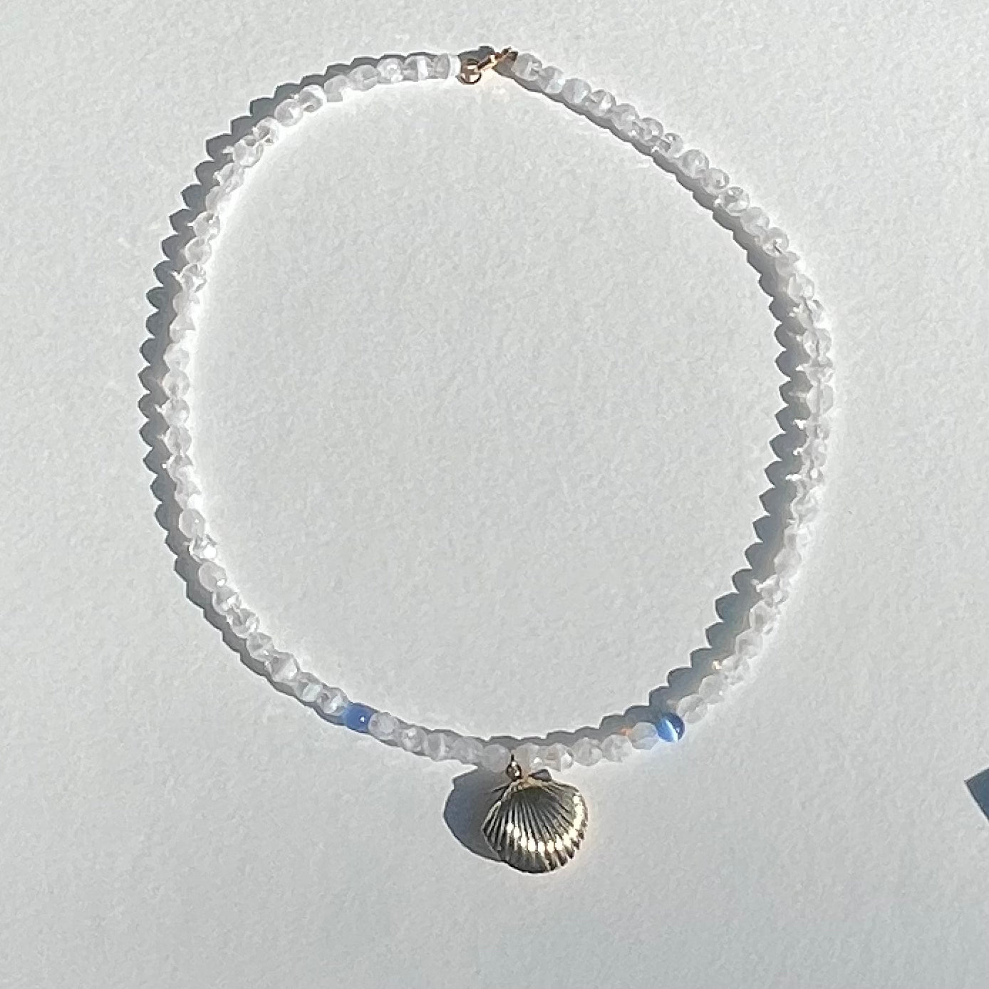 The Luke necklace a white and periwinkle blue glass beaded necklace with seashell gold locket